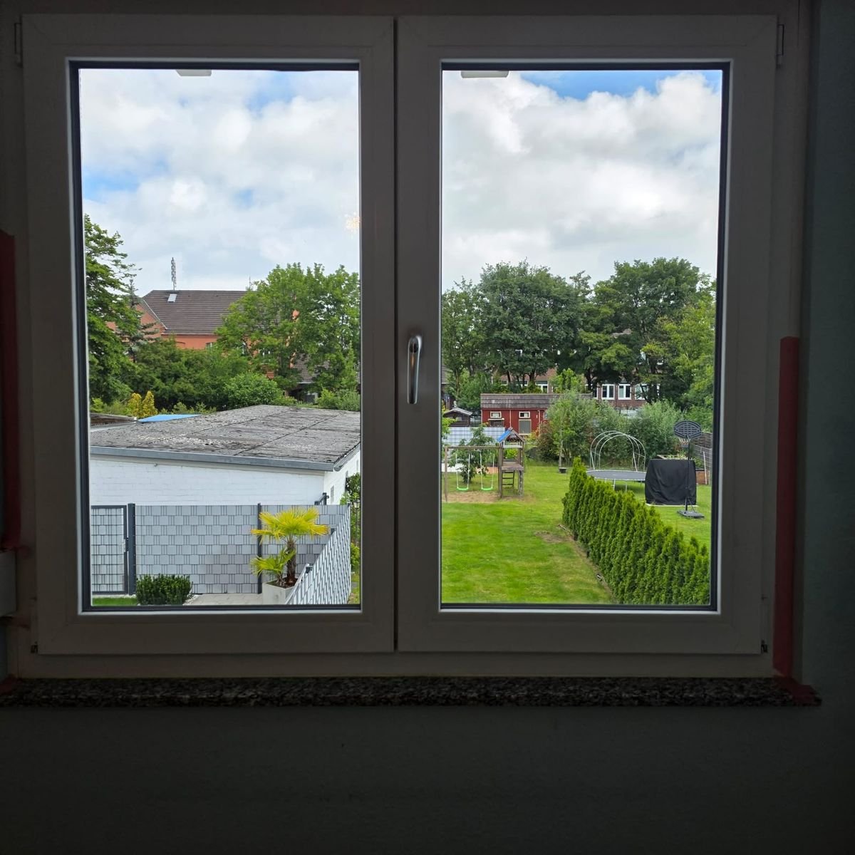 Blick durch ein sauberes Fenster in den Garten
