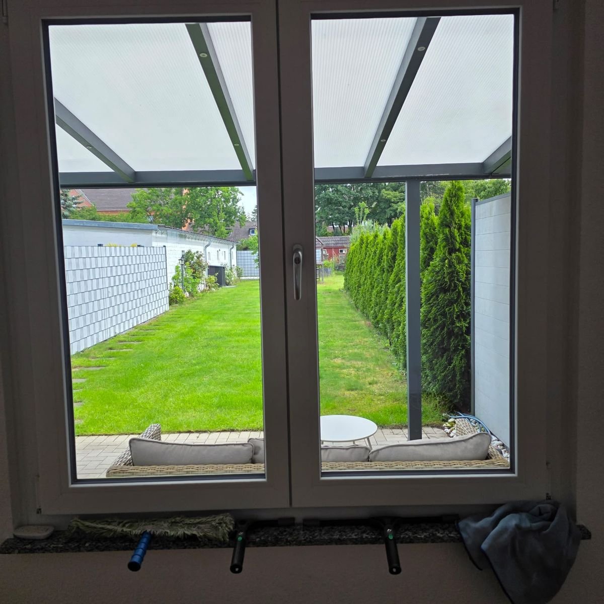 Sauberes Fenster mit Einwascher, Abzieher und Mikrofasertuch